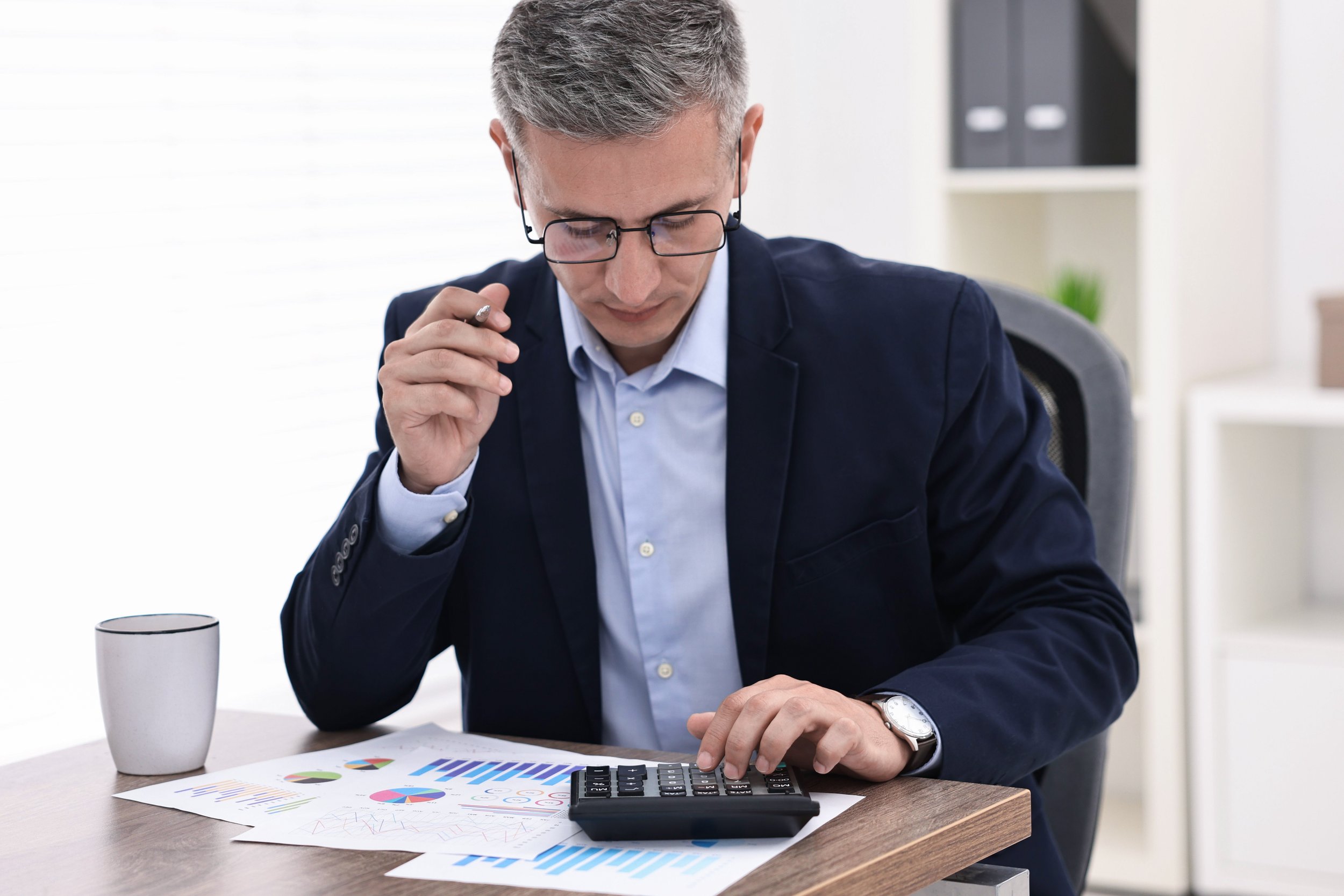 Injury management professional analyzing reports and calculations at a desk.