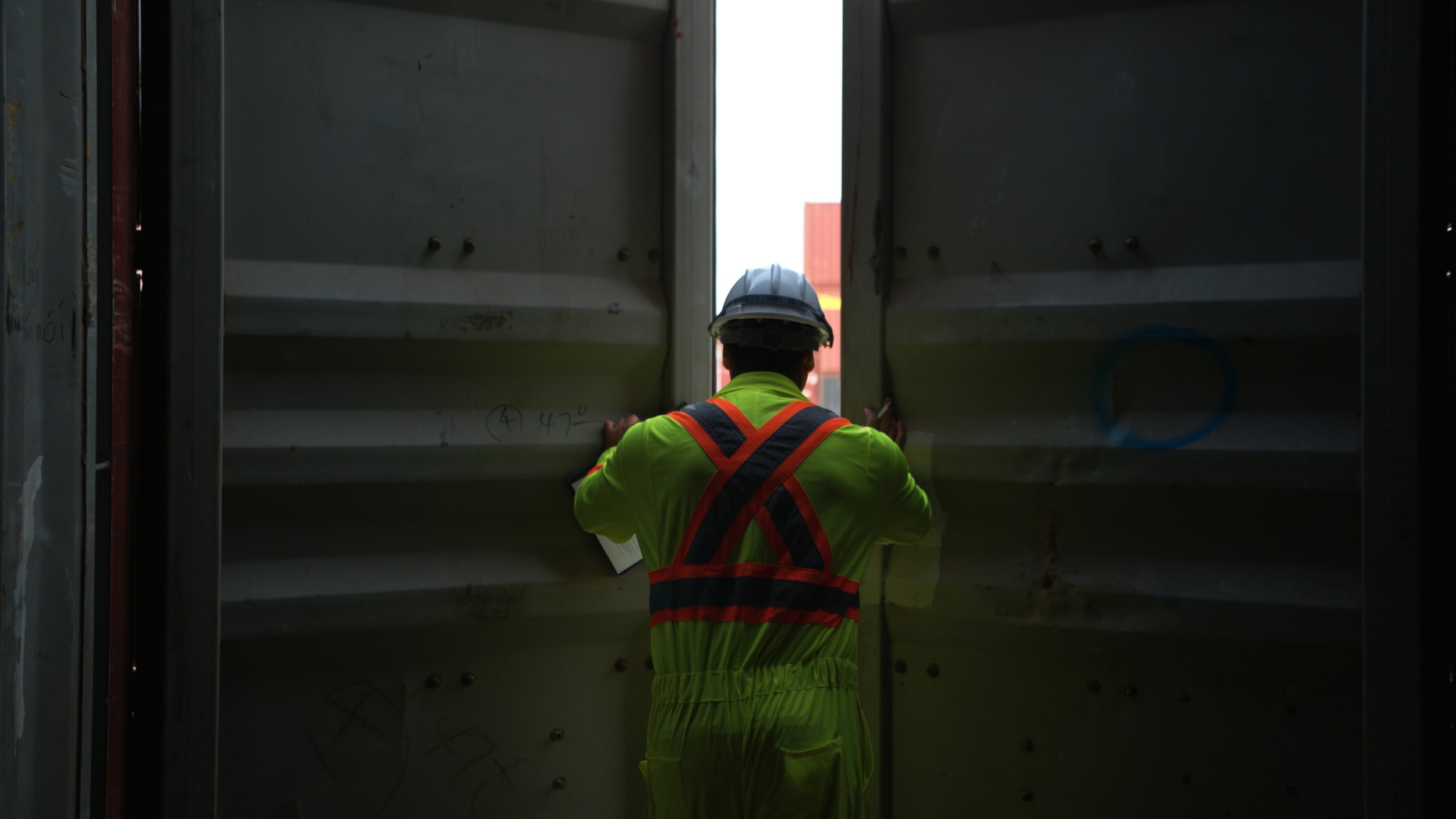 Worker in safety gear inspecting injury management equipment.